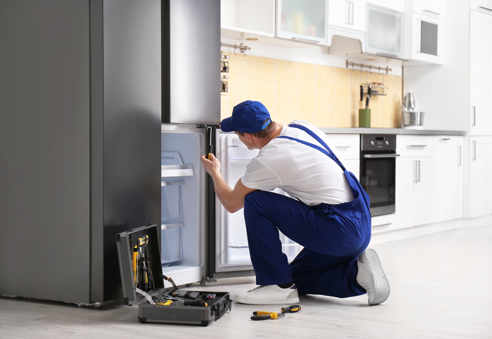 a technician repairing a refrigerator - North Charleston Appliance Repair Pros